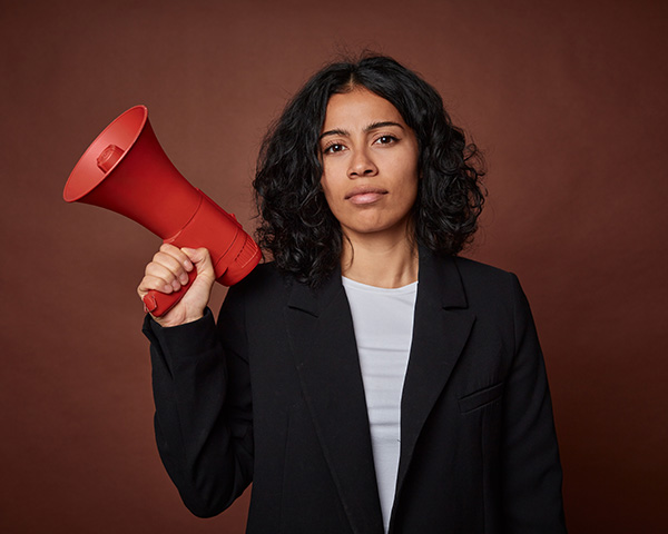 A young business woman passionately advocates for her rights with a megaphone.