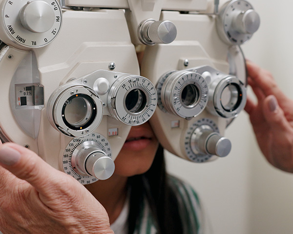 A person undergoing an eye examination with a phoropter.