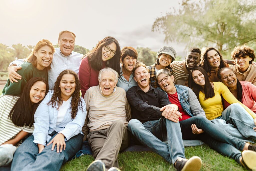 a group of diverse people laugh and smile outdoors