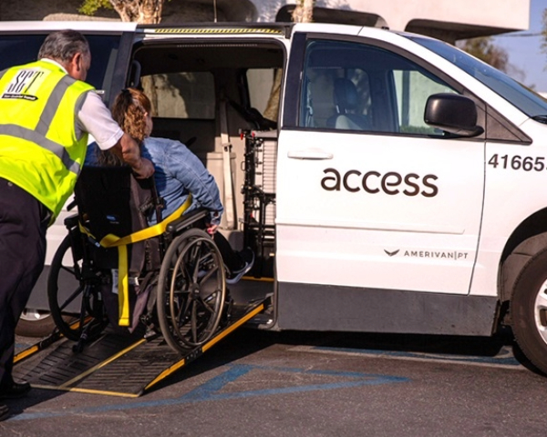 wheelchair bound woman going up ramp into access amerivan with the aid of driver