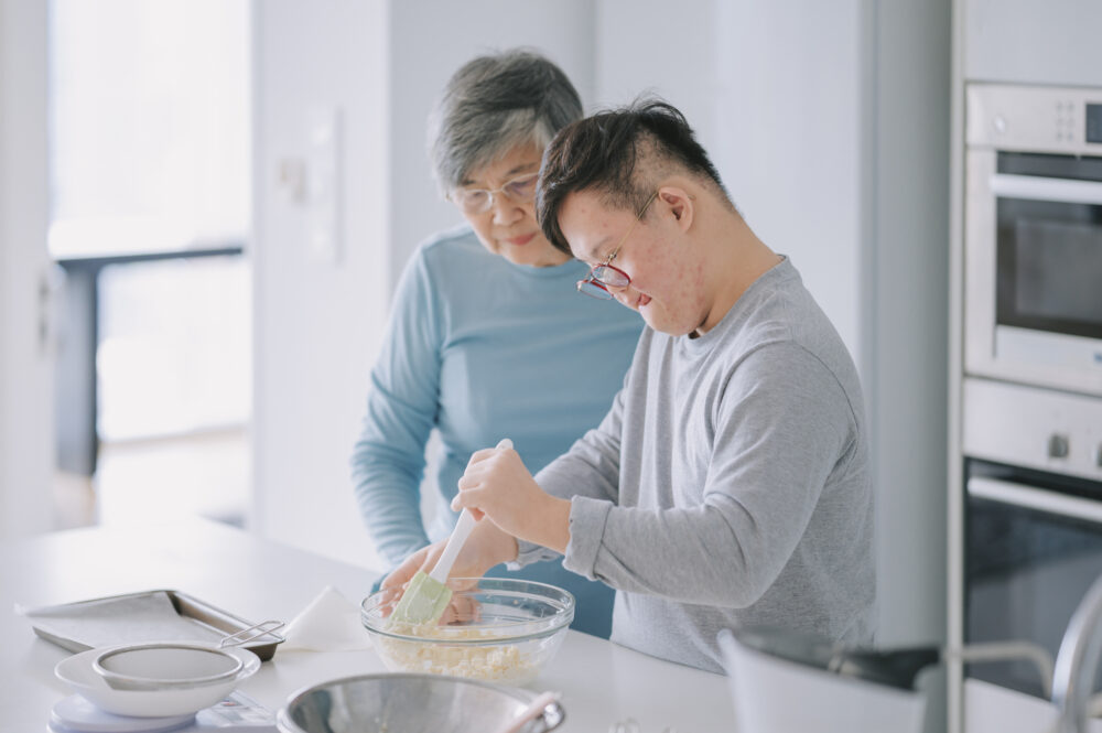 Asian boy with down syndrome baking with his grandmother